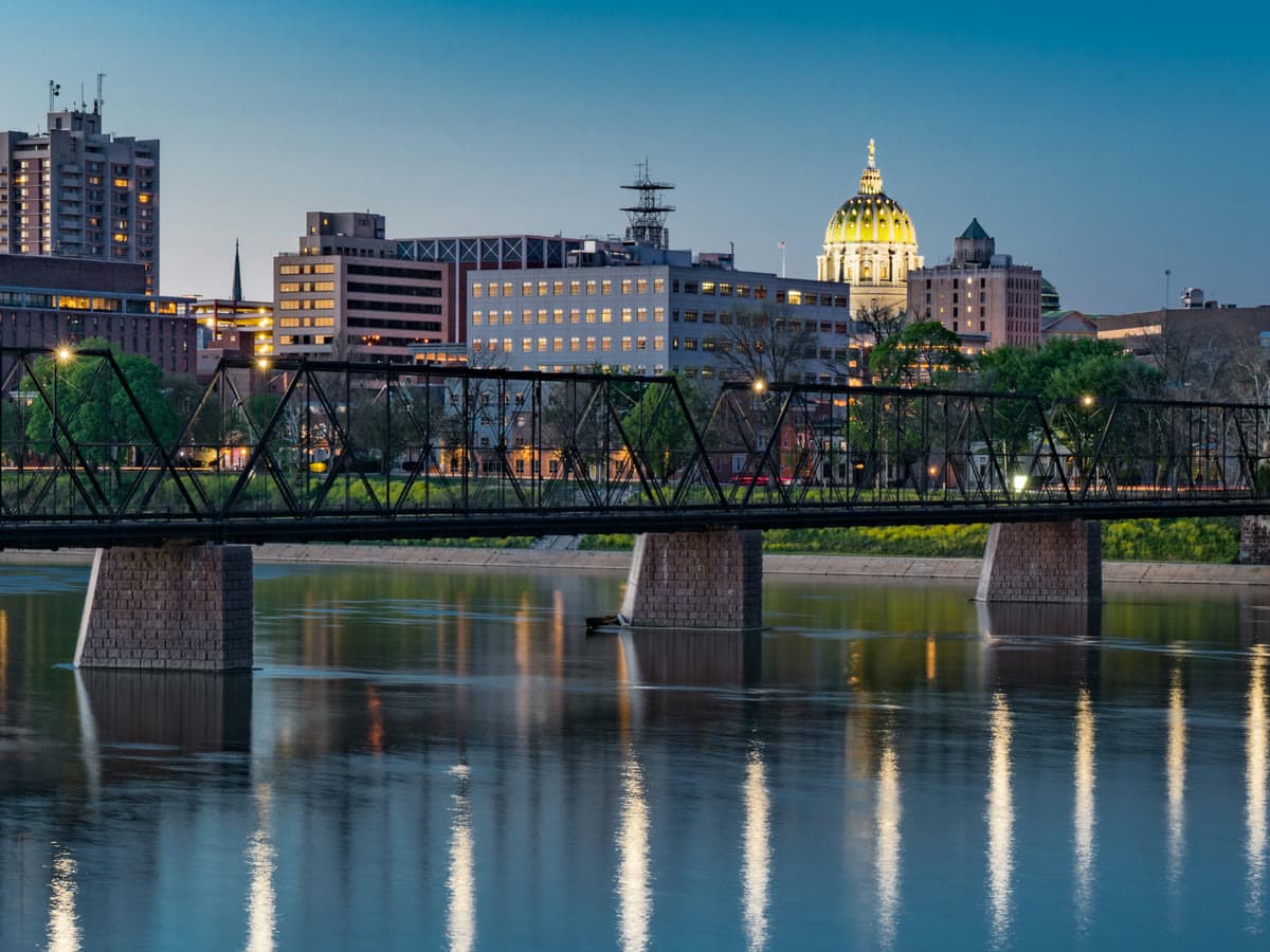 The Walnut Street Bridge over the Susquehanna River at dusk, with the Capitol dome and the Harrisburg skyline behind